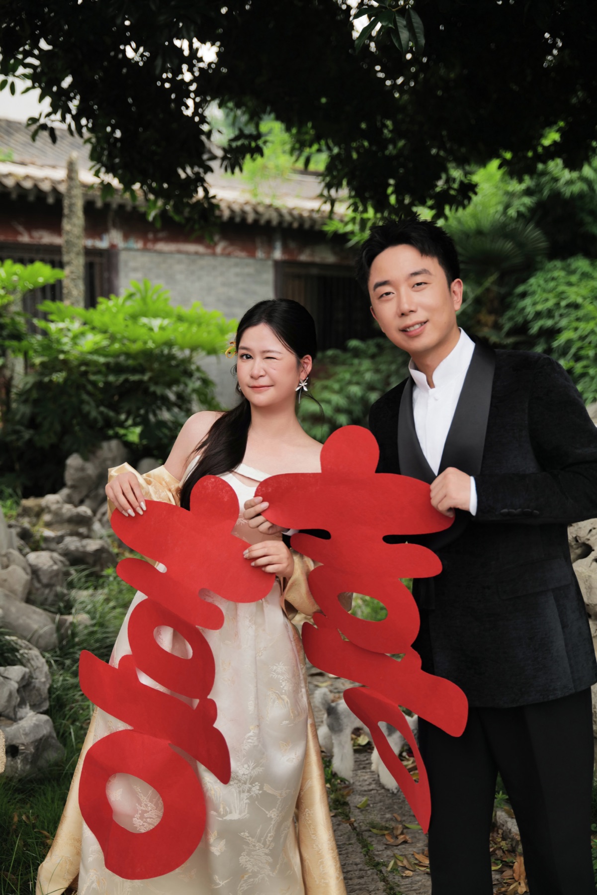 新郎新娘与红色喜字合影