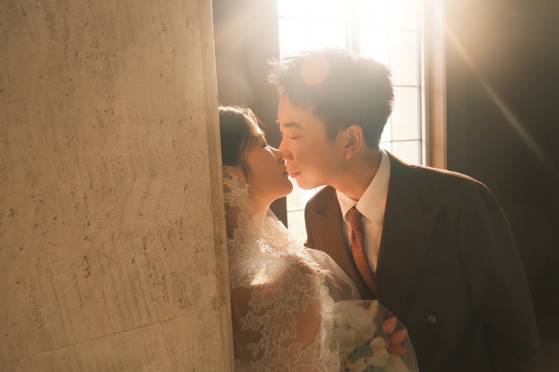 阳光下浪漫亲吻的婚纱照
